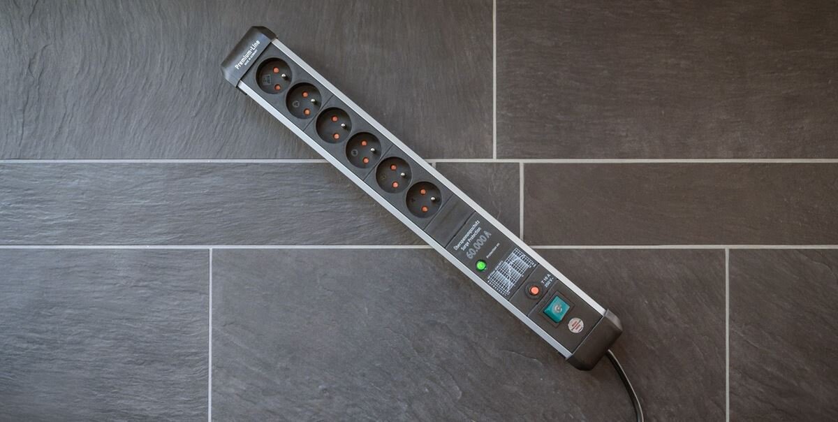 Listwa zasilająca z sześcioma gniazdami, przyciskiem zasilania i wskaźnikiem LED. Na listwie widoczne jest logo \'Brennenstuhl\'.