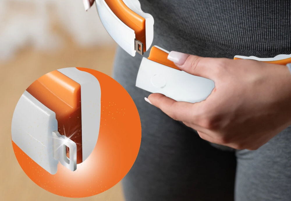 Osoba trzyma biało-pomarańczowy hula hop z mechanizmem zapięcia. W okrągłym powiększeniu pokazano szczegół zapięcia z białym i pomarańczowym elementem.