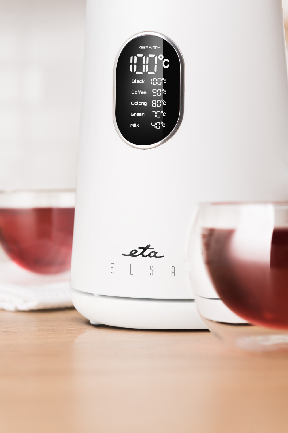 Biały czajnik z wyświetlaczem pokazującym temperatury dla różnych napojów: Black 100°C, Coffee 90°C, Oolong 80°C, Green 70°C, Milk 40°C. Na czajniku widoczne jest logo \'eta\' oraz napis \'ELSA\'.
