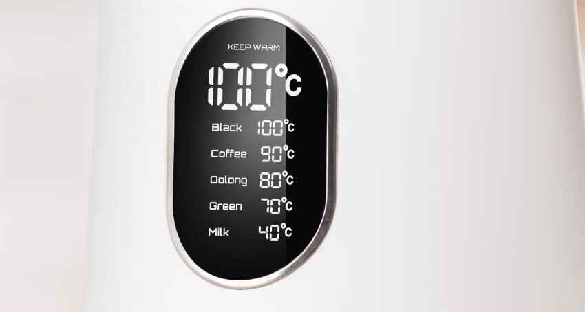 Wyświetlacz na białym czajniku pokazuje temperaturę 100°C z opcjami: Black 100°C, Coffee 90°C, Oolong 80°C, Green 70°C, Milk 40°C.