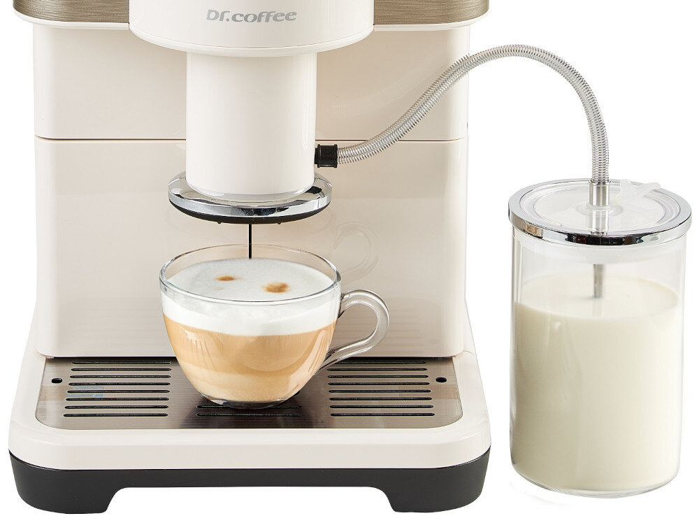 Biały ekspres do kawy z logo \'Dr.coffee\' przygotowuje kawę z mleczną pianką w szklanej filiżance. Obok znajduje się pojemnik z mlekiem podłączony do ekspresu metalową rurką.