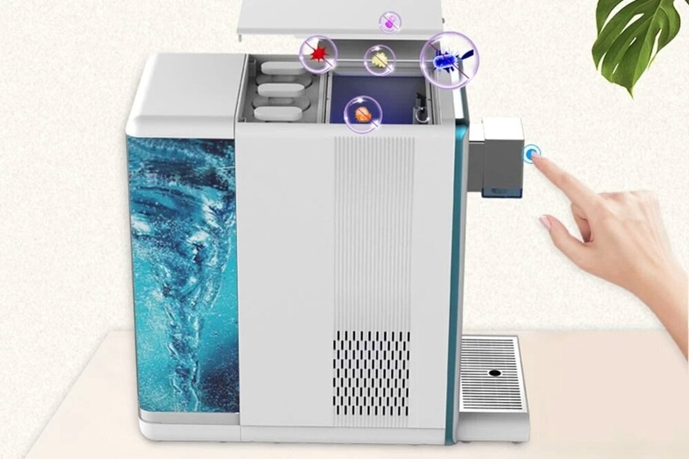 Na obrazie widoczny jest dyspenser do wody z otwartą pokrywą, ukazujący wnętrze z filtrami. Obok urządzenia znajduje się ręka naciskająca przycisk, a nad dyspenserem unoszą się kolorowe bańki z symbolami.