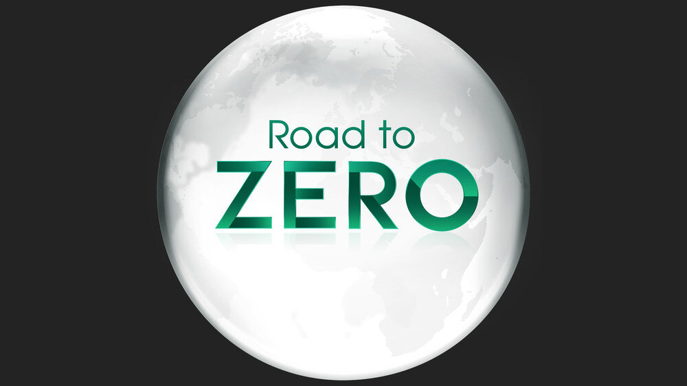 Na obrazie widoczna jest kula ziemska z napisem \'Road to ZERO\' na jej powierzchni. Tło jest ciemne, co podkreśla jasność kuli ziemskiej.