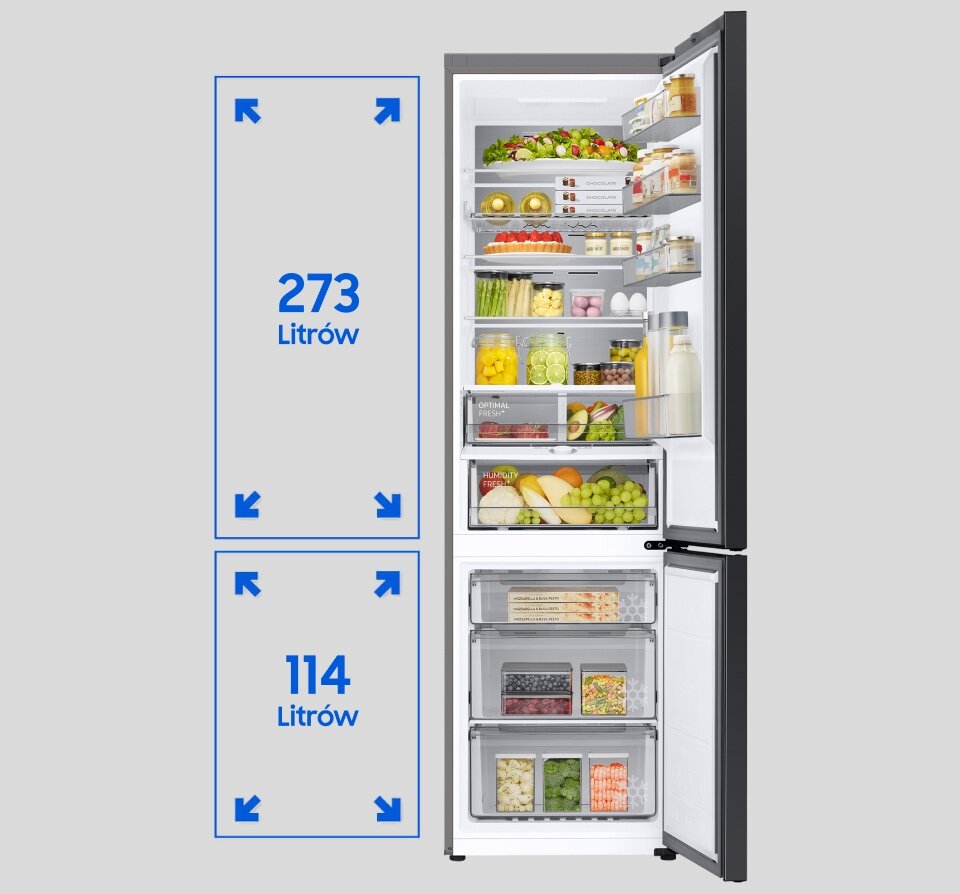 Otwarta lodówka z widocznymi półkami wypełnionymi różnymi produktami spożywczymi, takimi jak owoce, warzywa i napoje. Obok lodówki widoczna jest grafika z napisem \'273 Litrów\' i \'114 Litrów\'.