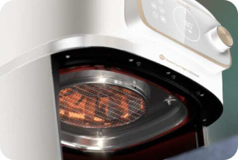 Zbliżenie na wnętrze frytkownicy beztłuszczowej z widocznym elementem grzewczym i metalową siatką. Na panelu sterowania widoczne są przyciski i pokrętło.