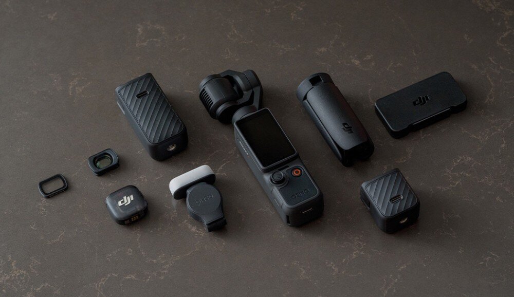 Kamera sportowa DJI OSMO POCKET 4 czarne urządzenie z kamerą, mniejsze akcesoria i obiektywy ułożone na ciemnym, teksturowanym blacie