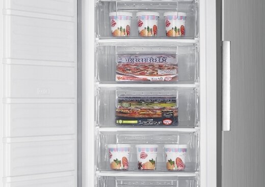 Wnętrze zamrażarki wypełnione pudełkami lodów i pizzy.