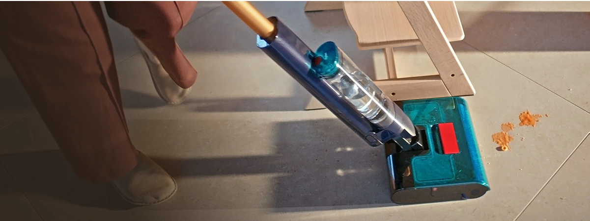 Widok mopa podczas mycia zabrudzonych płytek podłogowych manewrującego obok krzesła