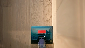 Mop zmywa podłogę przy samej krawędzi przy ścianie