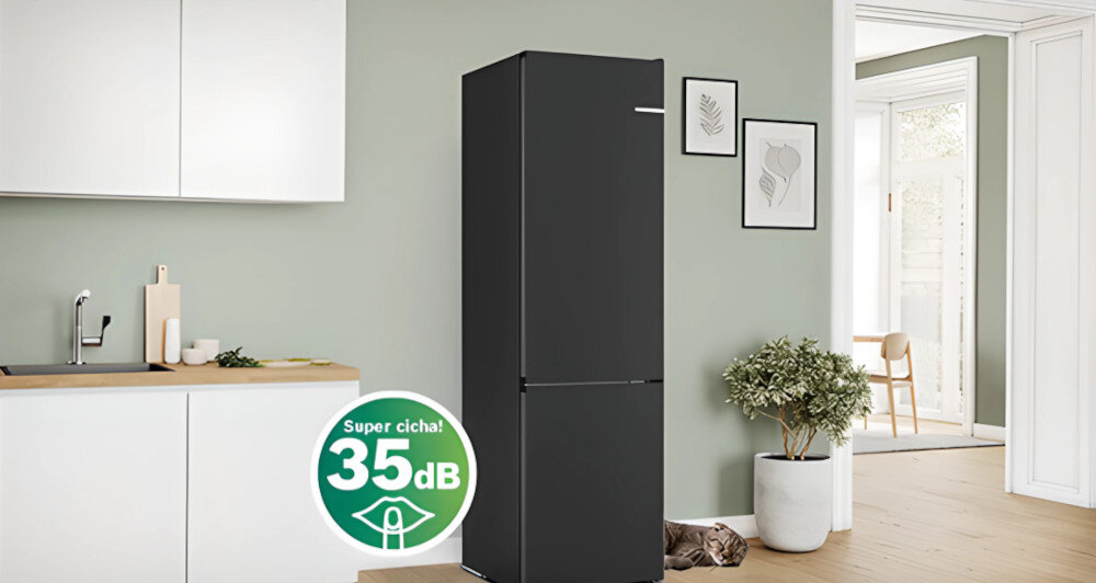 Czarna lodówka stoi w nowoczesnej kuchni z jasnymi szafkami i drewnianym blatem. Na obrazie widoczny jest zielony symbol z napisem \'Super cicha! 35 dB\'.