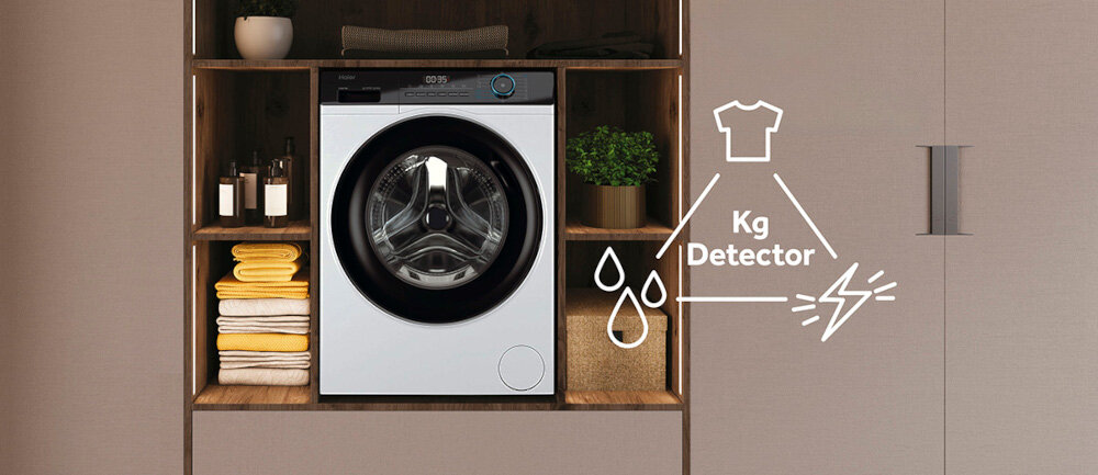 Pralka umieszczona w zabudowie meblowej, obok niej znajdują się ręczniki i rośliny. Na obrazie widoczny jest symbol koszulki z napisem \'Kg Detector\' oraz krople wody i błyskawica.