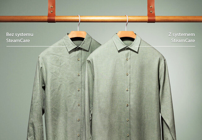 Na obrazie widoczne są dwa zielone koszule wiszące na drewnianym wieszaku. Po lewej stronie koszula jest pognieciona z napisem \'Bez systemu SteamCare\', a po prawej gładka z napisem \'Z systemem SteamCare\'.