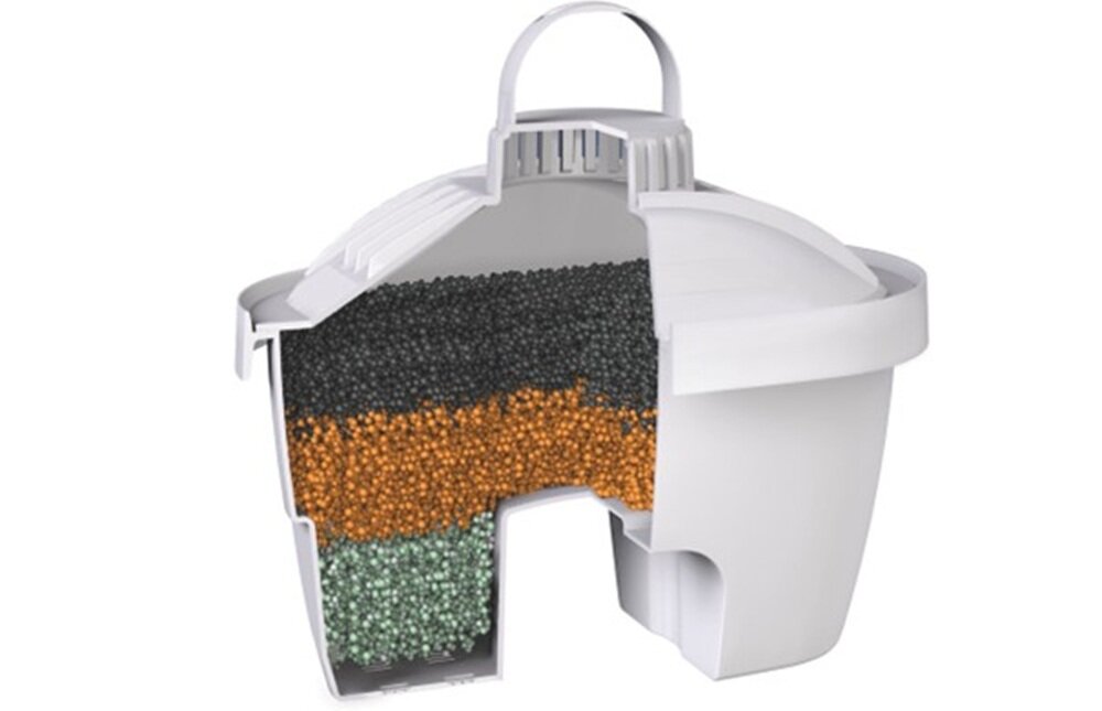 Przekrój wkładu filtrującego pokazujący trzy warstwy różnokolorowych granulek wewnątrz białej obudowy. Wkład ma uchwyt na górze i otwory na dole.