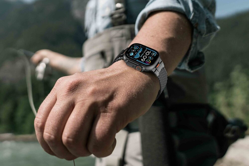 Pasek TECH-PROTECT Milano Vanguard do Apple Watch do koperty 44-45-46-49 mm Czarny osoba ma na nadgarstku bransoletę w tle góry woda odporna na zarysowania, korozję i codzienne otarcia przepuszcza powietrze przyjazna dla skóry nie powoduje alergii ani podrażnień