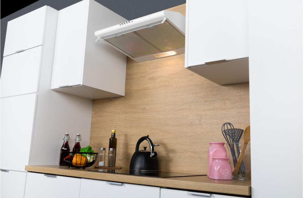 Kuchnia z białymi szafkami i drewnianym blatem, na którym stoją czajnik, butelki z oliwą i przyprawami oraz różowe naczynie z przyborami kuchennymi. Nad blatem zamontowany jest okap kuchenny w kolorze inox.