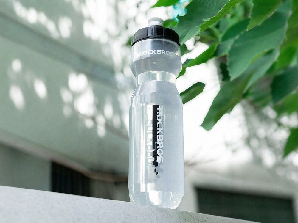 Bidon ROCKBROS DCBT69TBK 750 ml Przezroczysto-czarny, higiena, mycie, wycieczka, las, Otwarta butelka z leżącą obok nakrętką.