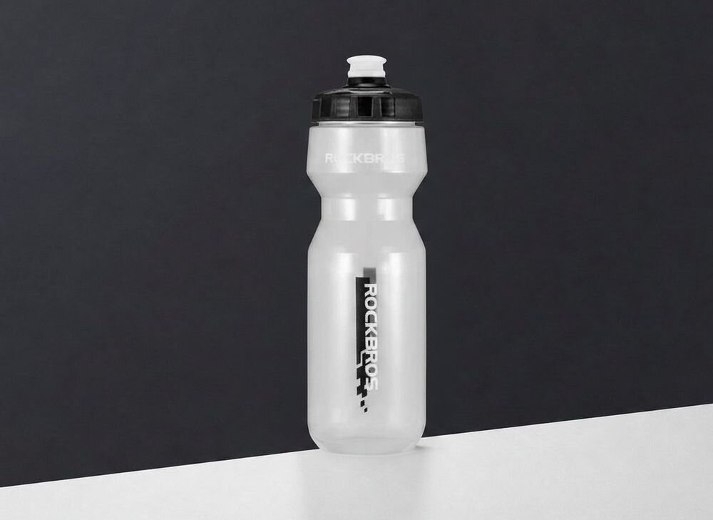 Bidon ROCKBROS DCBT69TBK 750 ml Przezroczysto-czarny, polipropylen, wytrzymałość, korek, smak, Butelka obok hantla, telefonu i zegarka.
