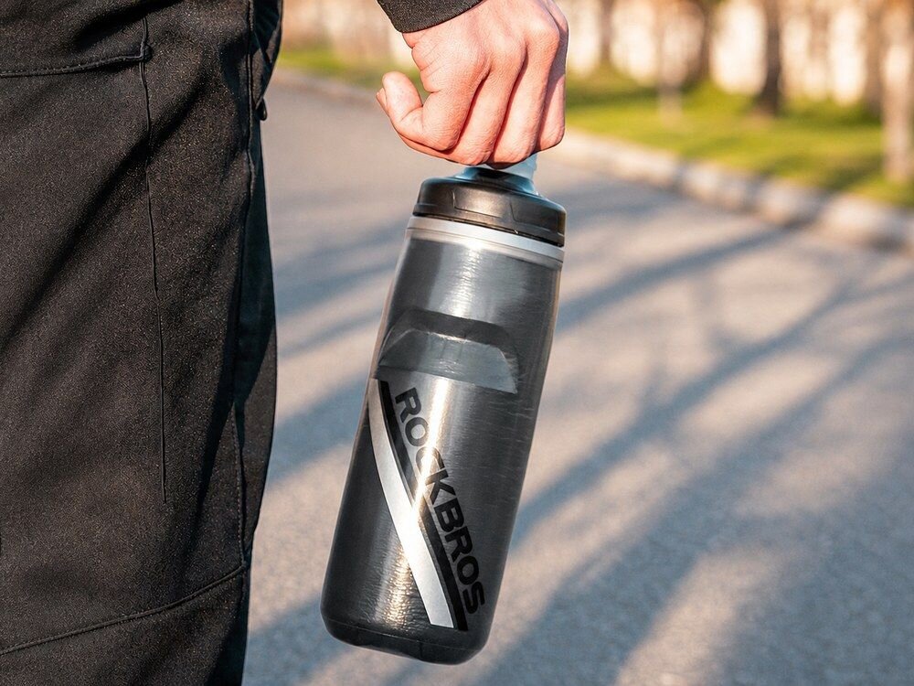 Bidon ROCKBROS 35210022002 620 ml Czarny, bidon, czarny, izolacja, chłód, Mężczyzna niosący bidon w dłoni.