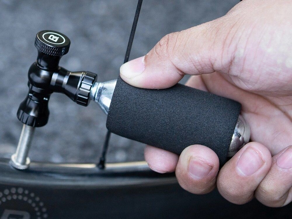Pompka rowerowa ręczna ROCKBROS CO2, ochrona, gąbka, zimno, nabój, Pompka CO2 z nabojem na ciemnych kamieniach.