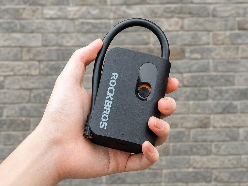 Pompka rowerowa elektryczna ROCKBROS L1 Mini, dłoń, pompka, motocykl, opona, Dłoń trzymająca pompkę elektryczną.
