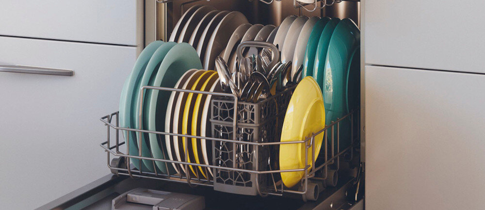 Otwarta zmywarka z widocznymi naczyniami, w tym talerzami w różnych kolorach oraz sztućcami w koszyku. Zmywarka jest wbudowana w szafkę kuchenną.