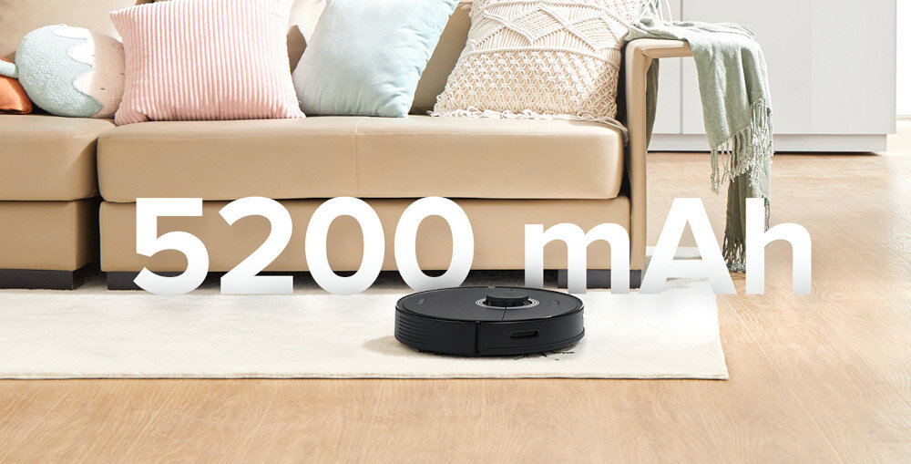 Na podłodze znajduje się czarny robot sprzątający. Widoczny jest napis \'5200 mAh\'.