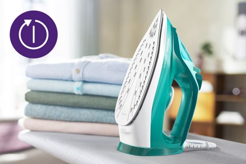 Na desce do prasowania stoi żelazko w kolorze turkusowym z białymi elementami, z widocznym napisem \'PHILIPS 3000 Series\'. Obok znajduje się stos złożonych ubrań, a w rogu widoczna jest ikona z symbolem włączania w fioletowym kółku.
