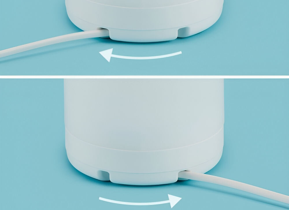 Obraz przedstawia dolną część białego urządzenia z kablem, na tle niebieskiej powierzchni. Widoczne są dwie strzałki wskazujące kierunek obrotu urządzenia.