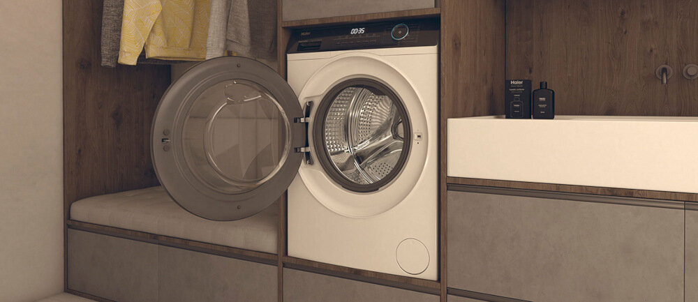 Pralka z otwartymi drzwiami znajduje się w zabudowie meblowej. Na wyświetlaczu widoczny jest czas 0:25, a obok pralki stoi umywalka z dwoma ciemnymi butelkami.