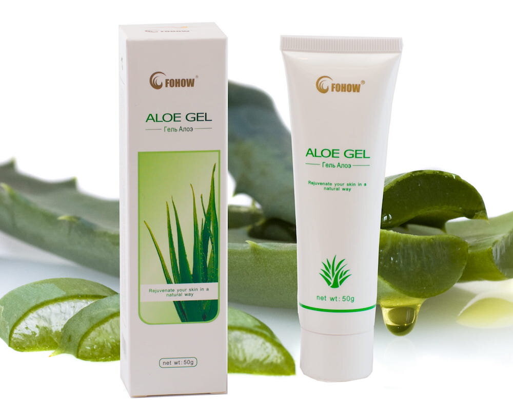 Na obrazie widoczny jest biały kartonik i tubka z napisem \'FOHOW ALOE GEL\'. W tle znajdują się fragmenty liści aloesu.