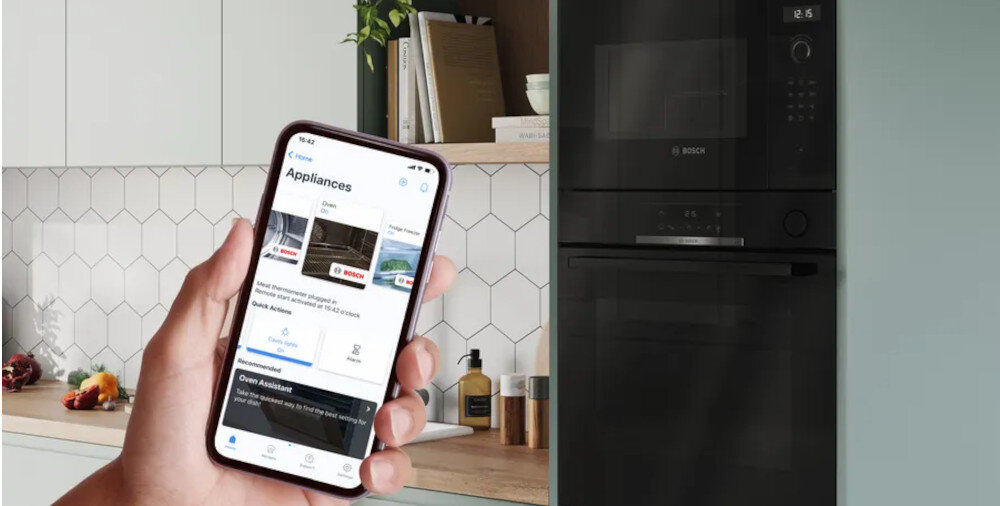 PIEKARNIK BOSCH HBG579EB7 kuchnia zabudowa smartfon w dłoni Aplikacja Home Connect zdalne sterowanie powiadomienia push