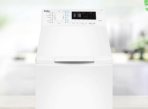 Biała pralka z widocznym panelem sterowania, na którym znajduje się pokrętło i wyświetlacz pokazujący czas 3:18. Na panelu widoczny jest napis \'Amica\'.