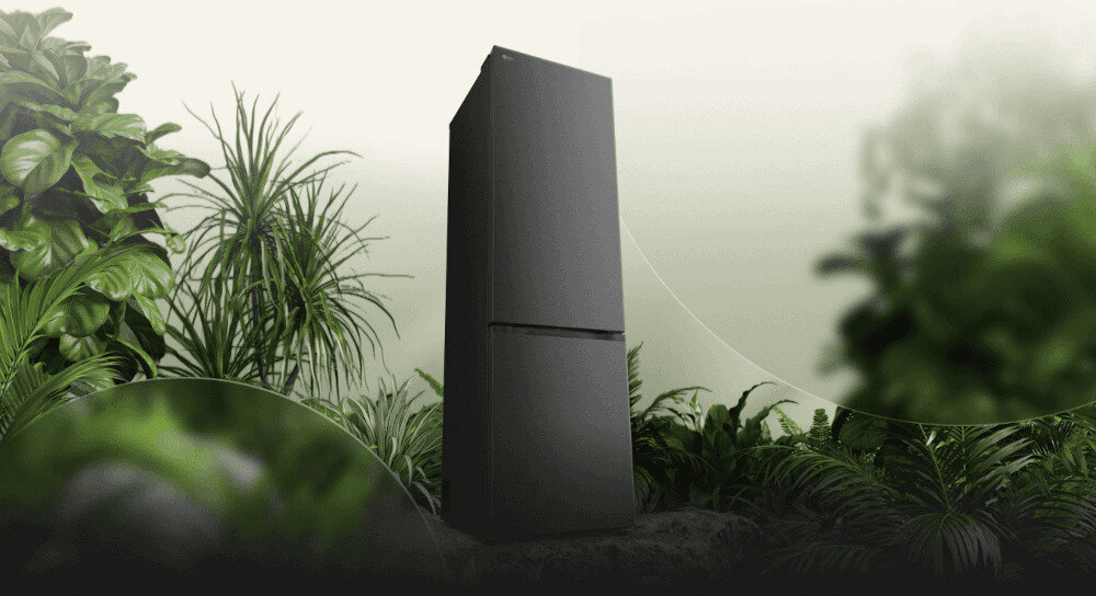 LODÓWKA LG GBBSJ2CCEP Grafika przedstawia smukłą, ciemnoszarą lodówkę LG ustawioną pośród bujnej, zielonej roślinności na tle jasnego, rozmytego nieba. Kompozycja podkreśla ekologiczny charakter urządzenia, kojarząc je z naturą i energooszczędnością energooszczędna efektywma praca klasa C