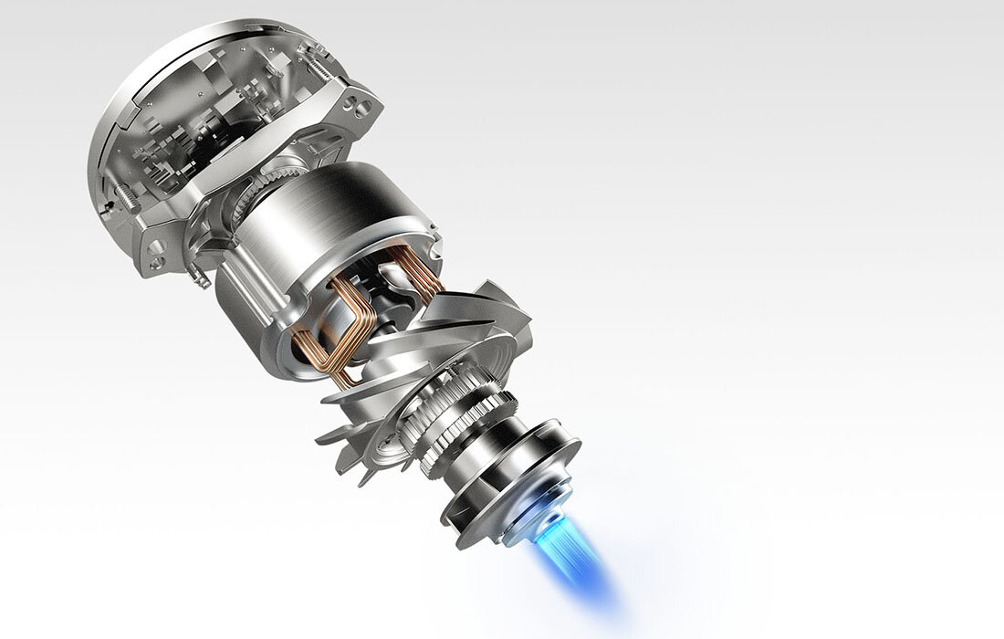 Obraz przedstawia metalowy mechanizm złożony z kilku cylindrycznych elementów, z których jeden emituje niebieskie światło. Konstrukcja ma srebrny kolor i widoczne są detale techniczne, takie jak zwoje i zębatki.