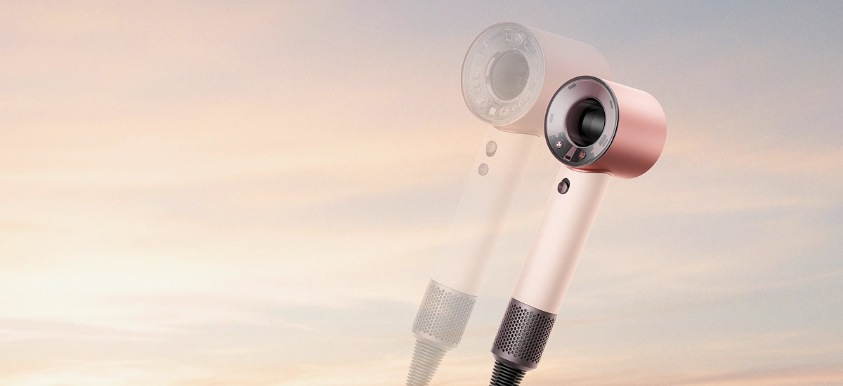 Jasnoróżowa suszarka pokazana na tle jasnego, różowo-błękitnego nieba. Obok niej jest jej półprzezroczyste powiększenie