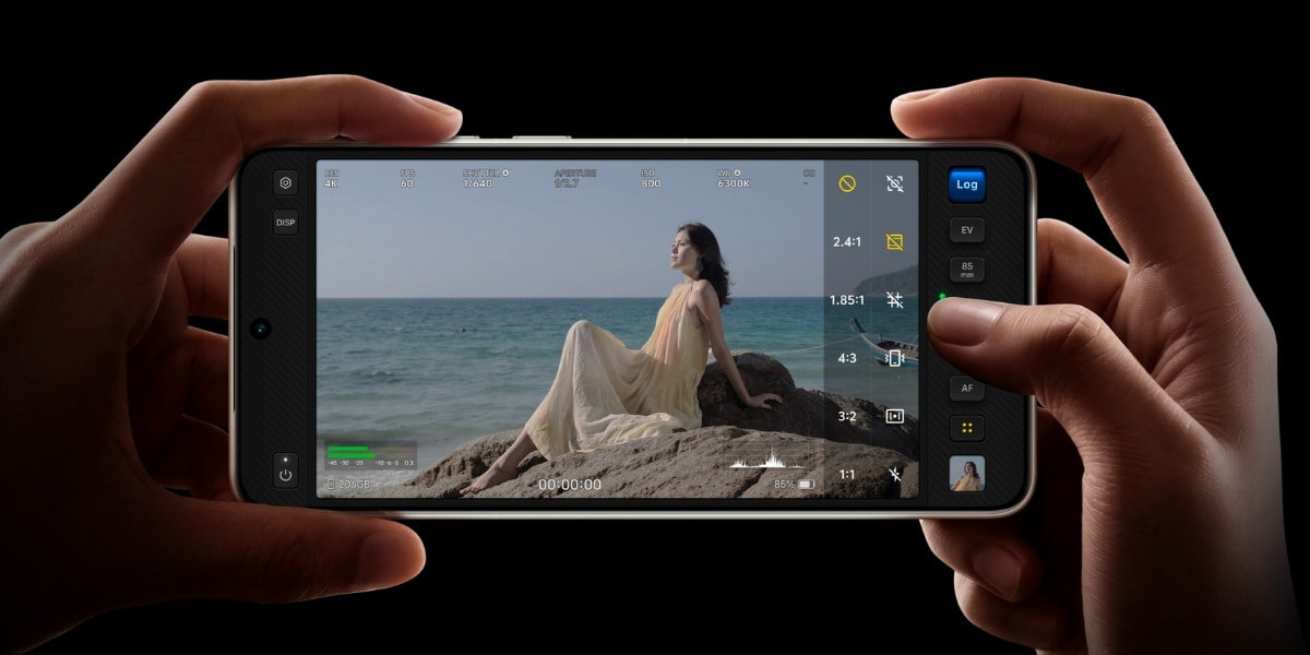 Smartfon trzymany w dwóch dłoniach w orientacji poziomej. Na ekranie widoczny tryb profesjonalnego nagrywania wideo z dużą ilością ustawień LUT AF 60 kl./s K 120 kl./s 10-bit LOG Wideo Pro
