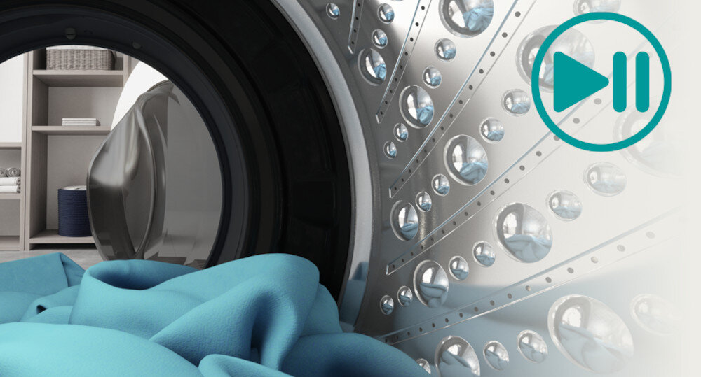 Widok wnętrza bębna pralki z niebieskim materiałem w środku. Po prawej stronie znajduje się symbol odtwarzania/pauzy w kolorze turkusowym.