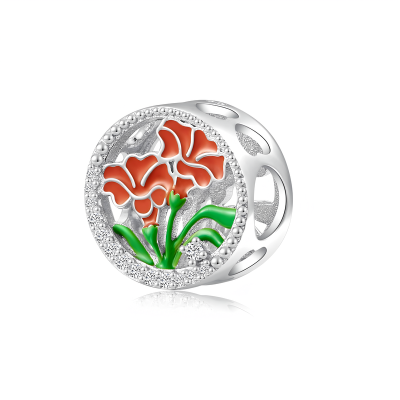 Srebrna zawieszka charms z motywem dwóch czerwonych goździków i zielonych łodyg, otoczona ozdobnym wzorem z małych kuleczek. Elementy kwiatowe są umieszczone na ażurowym tle.