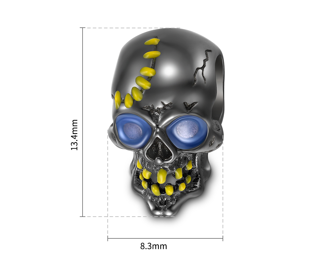 Srebrna zawieszka w kształcie czaszki z niebieskimi oczami i żółtymi detalami. Wymiary zawieszki to 13,4 mm na 8,3 mm.
