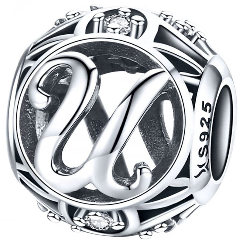 Srebrna zawieszka charms z literą \'U\' ozdobiona drobnymi kamieniami. Na boku widoczny jest napis \'S925\'.