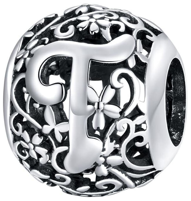 Srebrna zawieszka charms z literą \'T\' otoczona ażurowym wzorem z motywem kwiatowym. Wykonana z metalu o błyszczącej powierzchni.