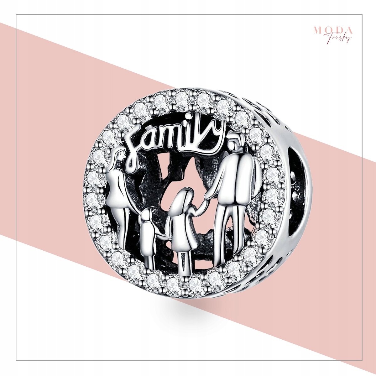 Srebrna zawieszka charms z napisem \'family\' i motywem rodziny, otoczona błyszczącymi kamieniami. W tle widoczne jest logo \'MODA FASHION\'.