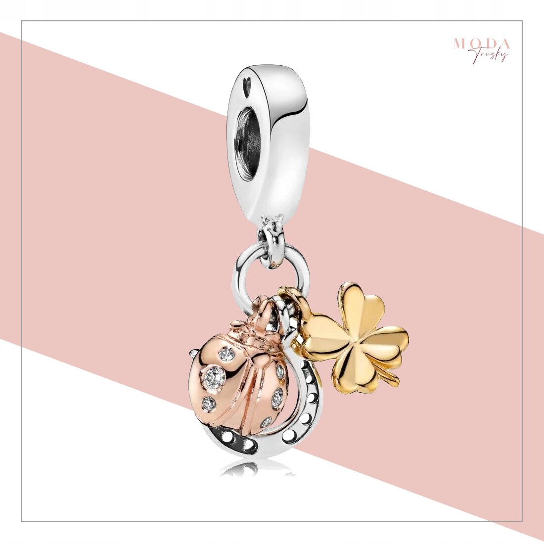 Zawieszka charms z motywem biedronki, koniczyny i podkowy, wykonana z metalu w kolorze srebrnym i złotym z ozdobnymi kamieniami. W tle widoczne jest logo \'MODA Trusky\'.