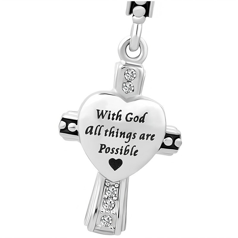Zawieszka w kształcie krzyża z sercem, ozdobiona błyszczącymi kamieniami. Na sercu widnieje napis: \'With God all things are Possible\'.