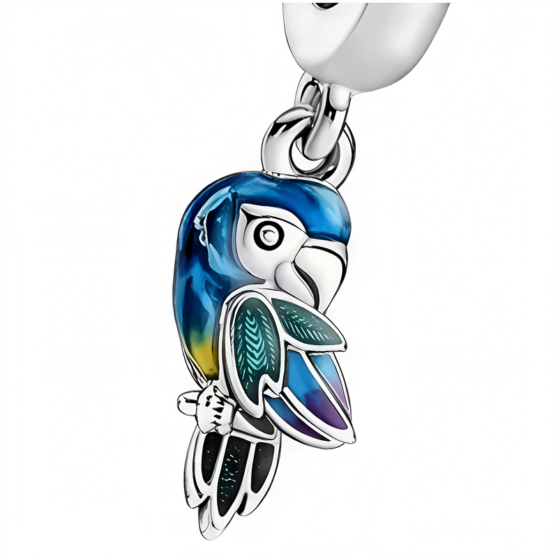 Zawieszka charms w kształcie papugi z kolorowym upierzeniem w odcieniach niebieskiego, zielonego i żółtego. Papuga ma szczegółowo wykonane pióra i jest przymocowana do metalowego uchwytu.