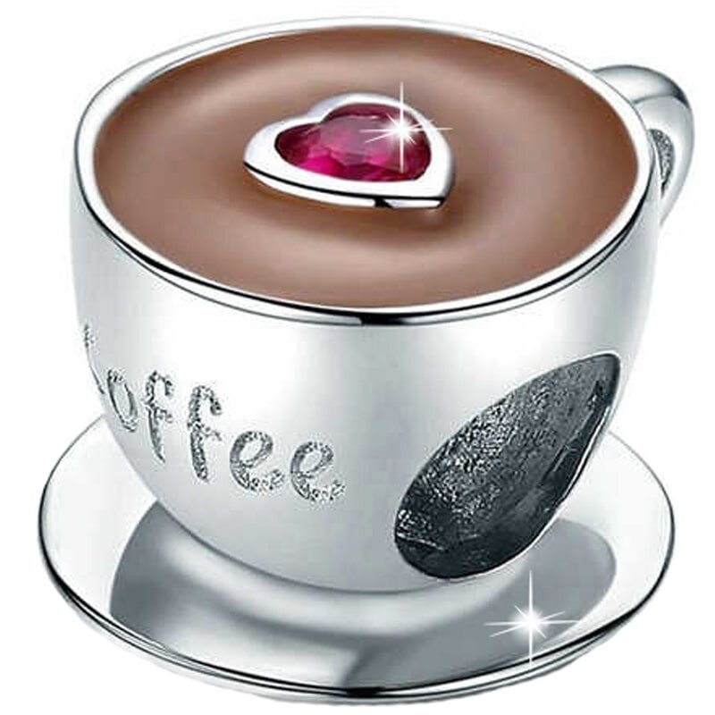 Srebrna zawieszka w kształcie filiżanki z napisem \'coffee\', z czerwonym sercem na powierzchni napoju. Filiżanka stoi na spodku, a całość wykonana jest z połyskującego materiału.