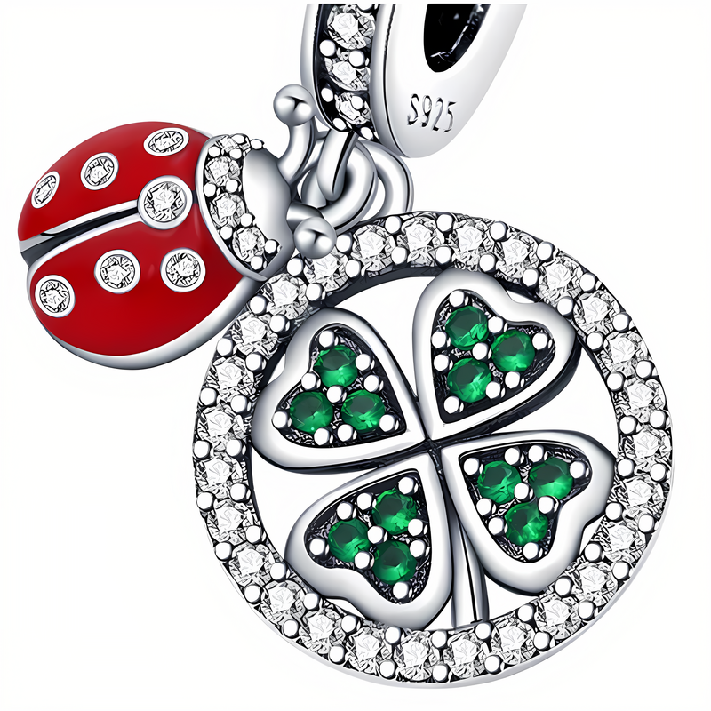 Zawieszka charms przedstawia koniczynkę z zielonymi kamieniami i cyrkoniami oraz czerwoną biedronkę z białymi kropkami. Na metalowej części widoczny jest napis \'S925\'.