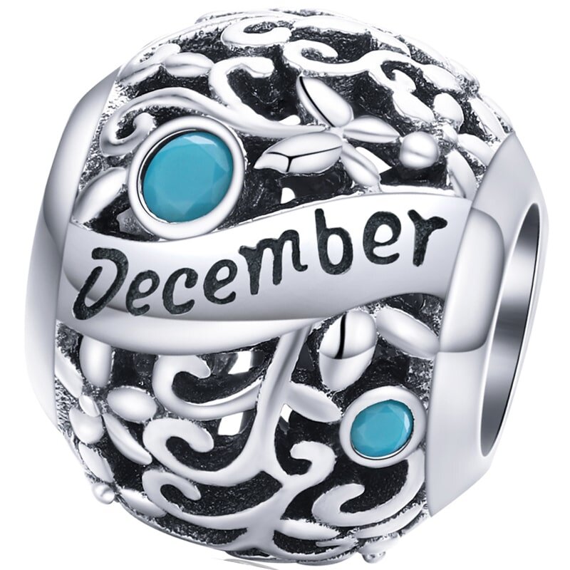 Srebrny charms z ażurowym wzorem i dwoma niebieskimi kamieniami. Na powierzchni widnieje napis \'December\'.