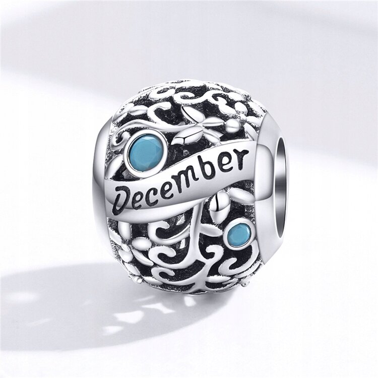 Srebrny charms z ażurowym wzorem i niebieskimi kamieniami, z napisem \'December\'.