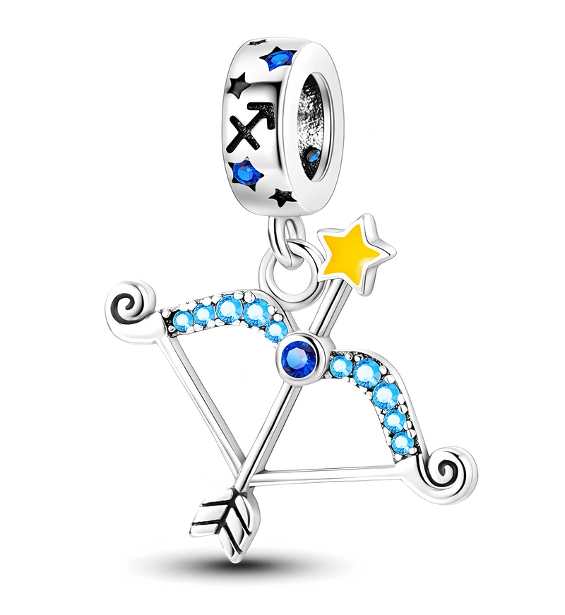 Zawieszka charms przedstawiająca łuk i strzałę ozdobioną niebieskimi kamieniami oraz żółtą gwiazdą. Na uchwycie widoczne są symbole zodiaku i niebieskie kamienie.